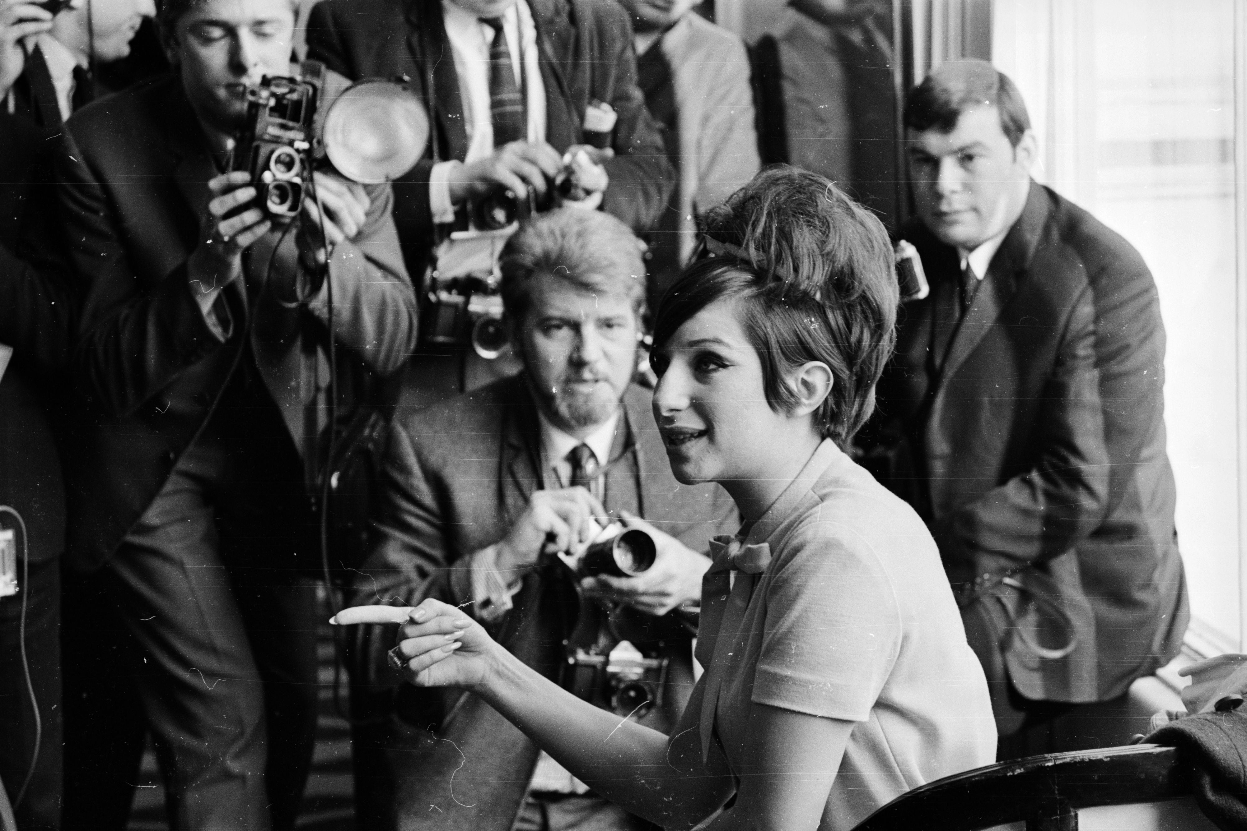 Streisand surrounded by press photographers in 1965