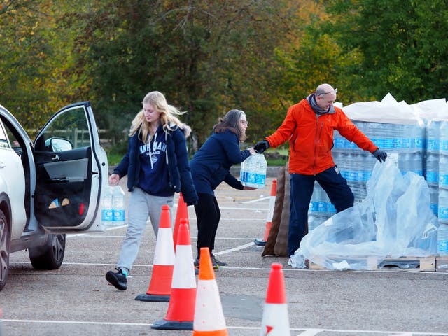 <p>Residents of Godalming, Surrey, collect bottles of water after Storm Ciarán left the town without running water</p>