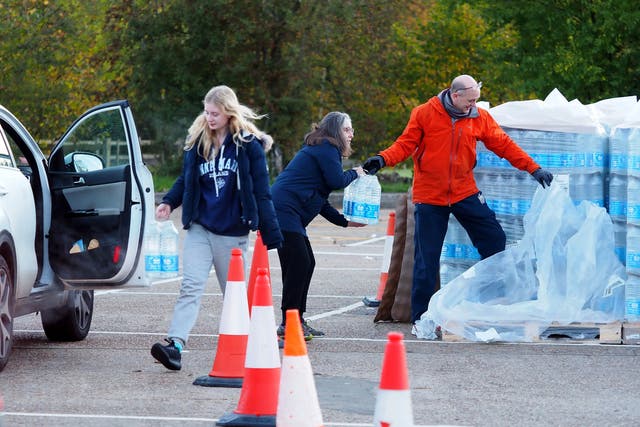 <p>Residents of Godalming, Surrey, collect bottles of water after Storm Ciarán left the town without running water</p>