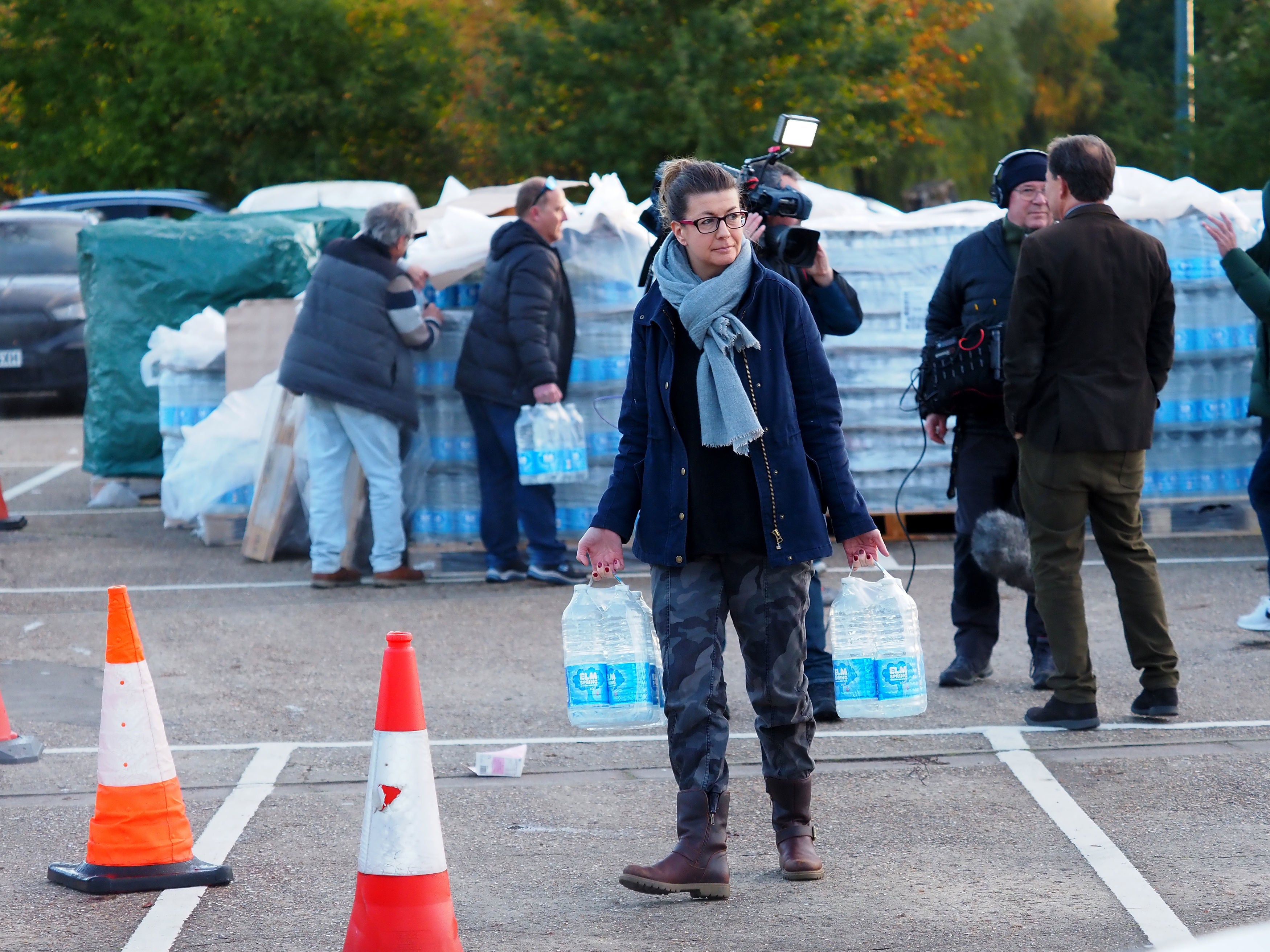 A Surrey resident collects bottled water amid shortages caused by Storm Ciarán