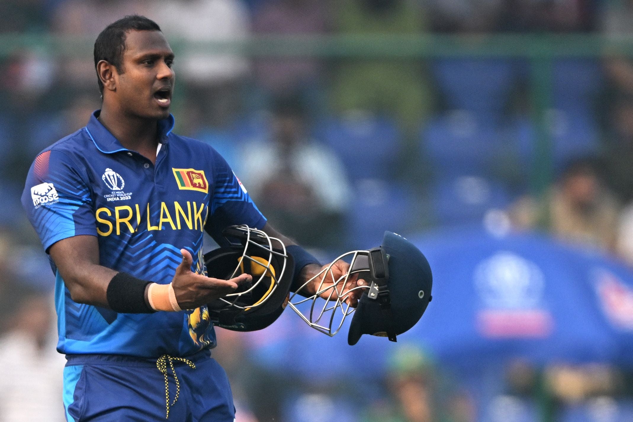 Angelo Mathews holds two helmets after one broke which led to him being timed out