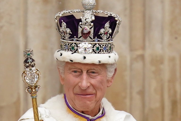 King Charles wearing the Imperial State Crown leaving his coronation ceremony in May