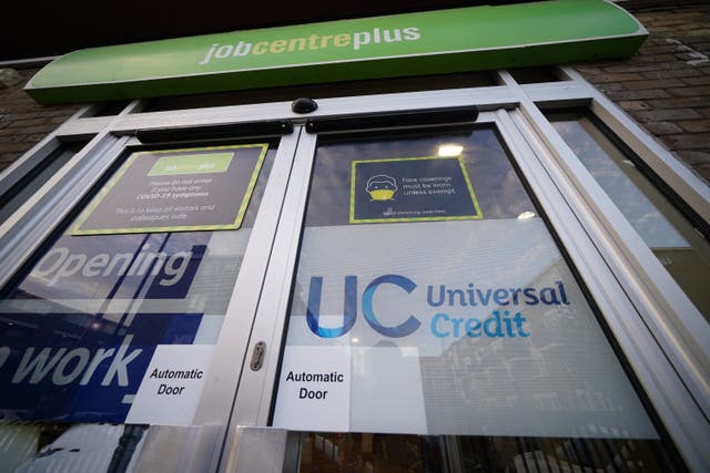 A Universal Credit sign on a door of a job centre plus in east London (Yui Mok/PA)