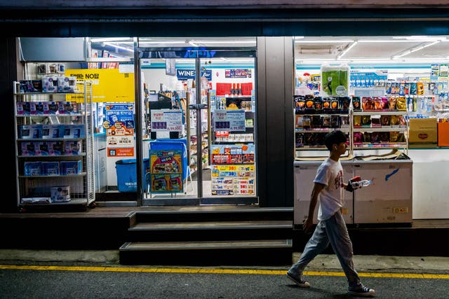 <p>A man walks past a convenience store along a street in Seoul. Representational</p>