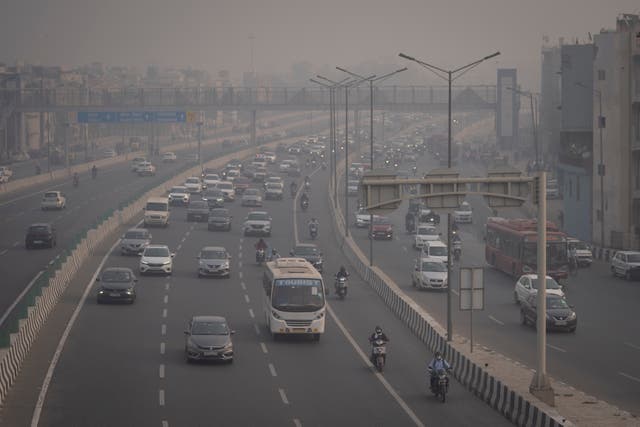 <p>Motorcyclists drive wearing pollution masks amid smog in New Delhi</p>