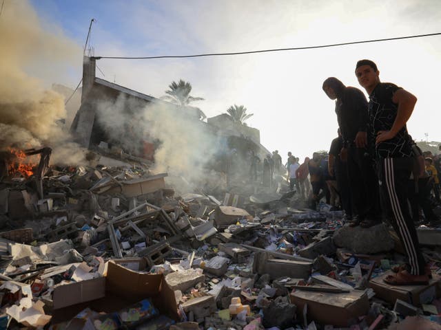 <p>Palestinians stand above debris after Israeli bombardment in Khan Yunis in the southern Gaza Strip on 7 November 2023, amid continuing battles between Israel and the Palestinian militant group Hamas</p>
