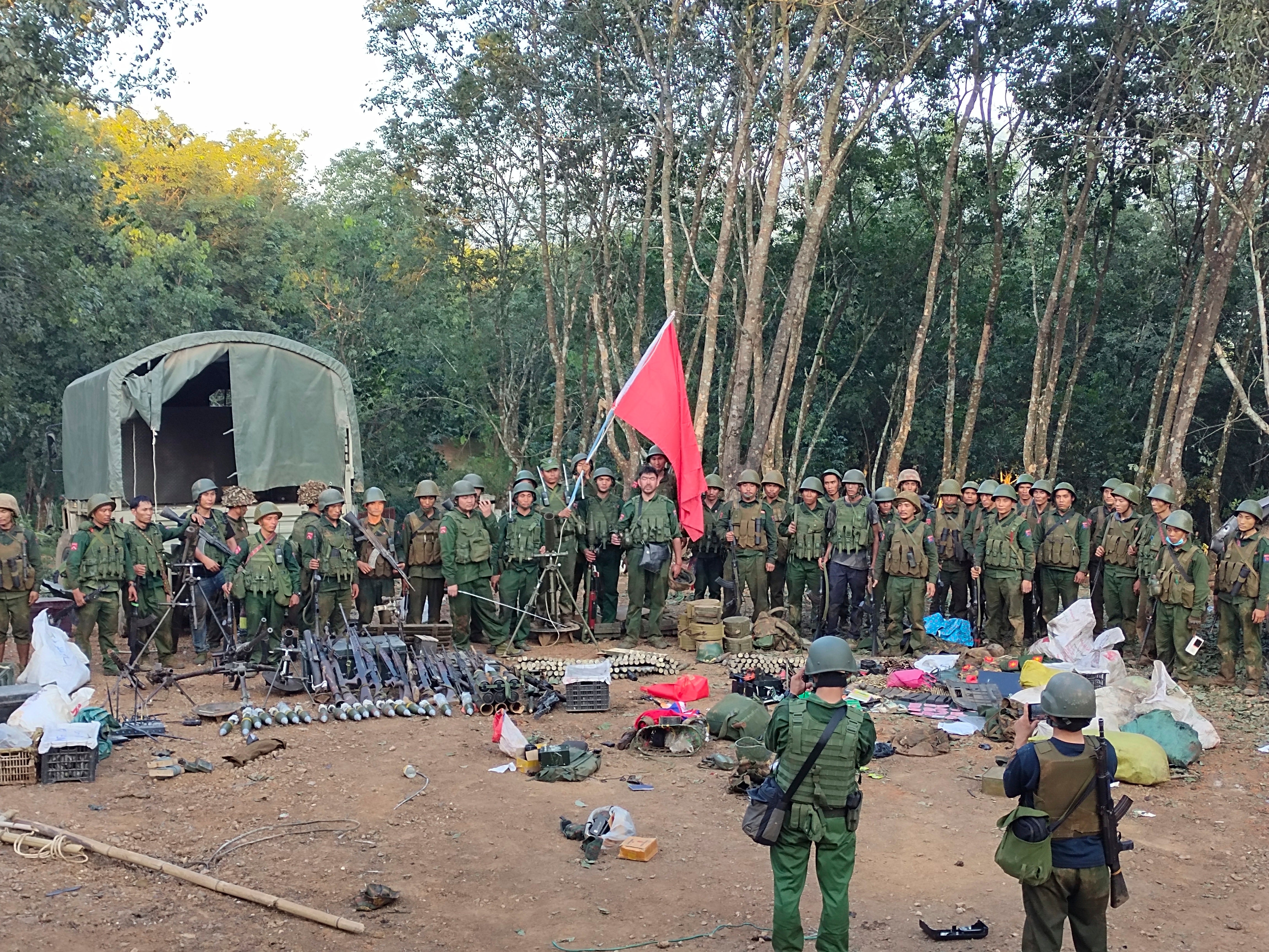 Members of the Myanmar National Democratic Alliance Army pose for a photograph with the weapons allegedly seized from the Myanmar’s army outpost on a hill in Chinshwehaw town, Myanmar