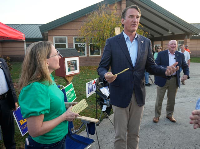 <p>Virginia Gov. Glenn Youngkin, right, hands out sample ballots along with Virginia State Sen. Siobhan Dunnavant R-Henrico, as they greet voters at a polling station Tuesday Nov. 7, 2023, in Glenn Allen, Virginia</p>