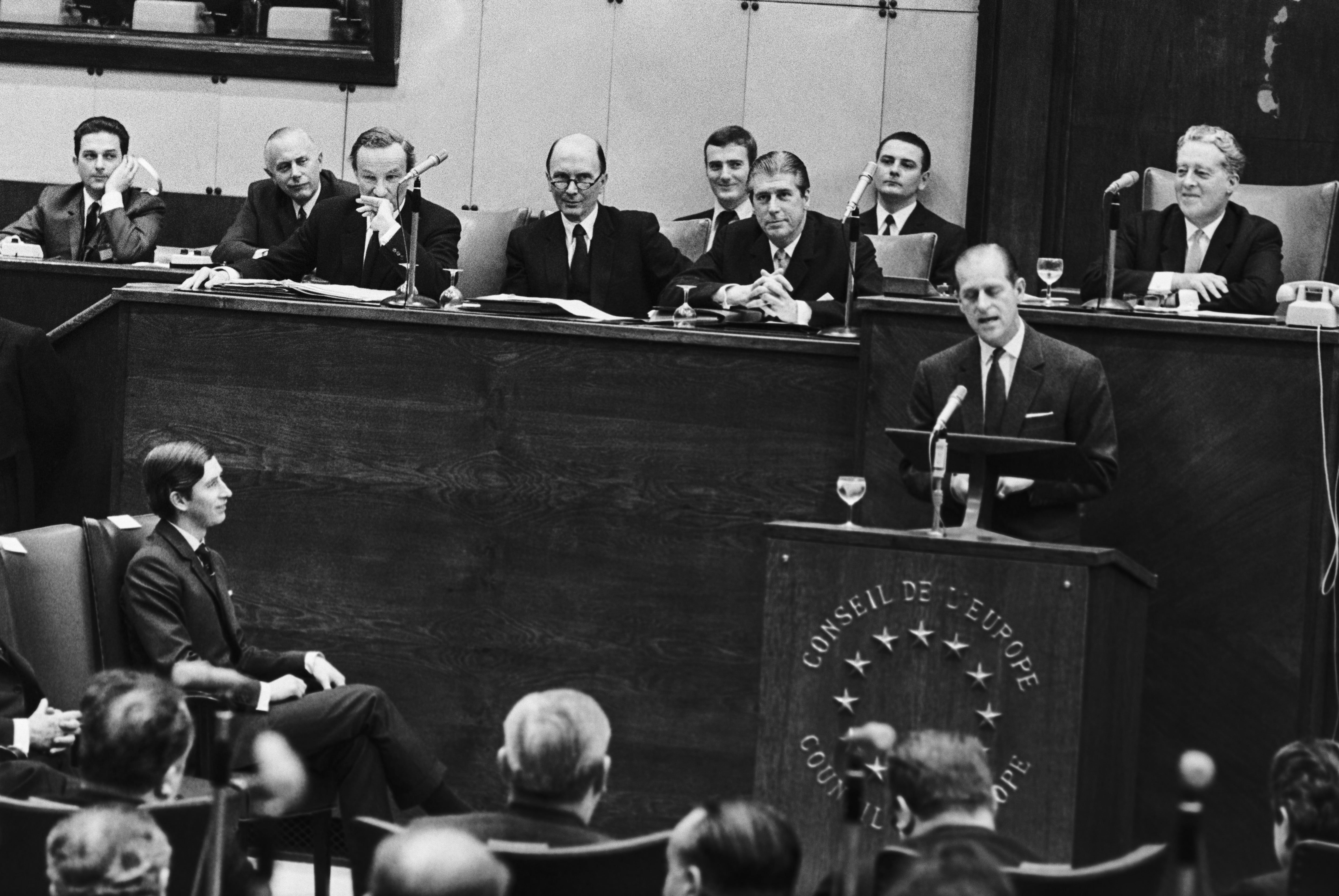 Prince Charles (left, seated) looks on as Prince Philip speaks at the World Pollution Conference in Strasbourg in 1970