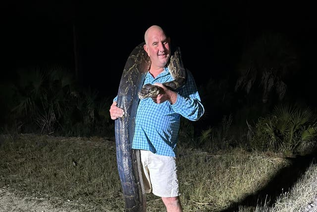 <p>Mike Elfenbein, 45, captured the snake along with his son and three hunters </p>