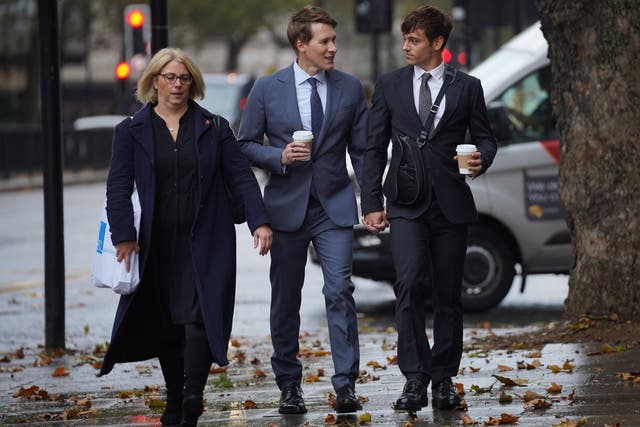 Dustin Lance Black, centre, arrives at Westminster Magistrates’ Court with his husband Tom Daley, right, on Wednesday (Lucy North/PA)