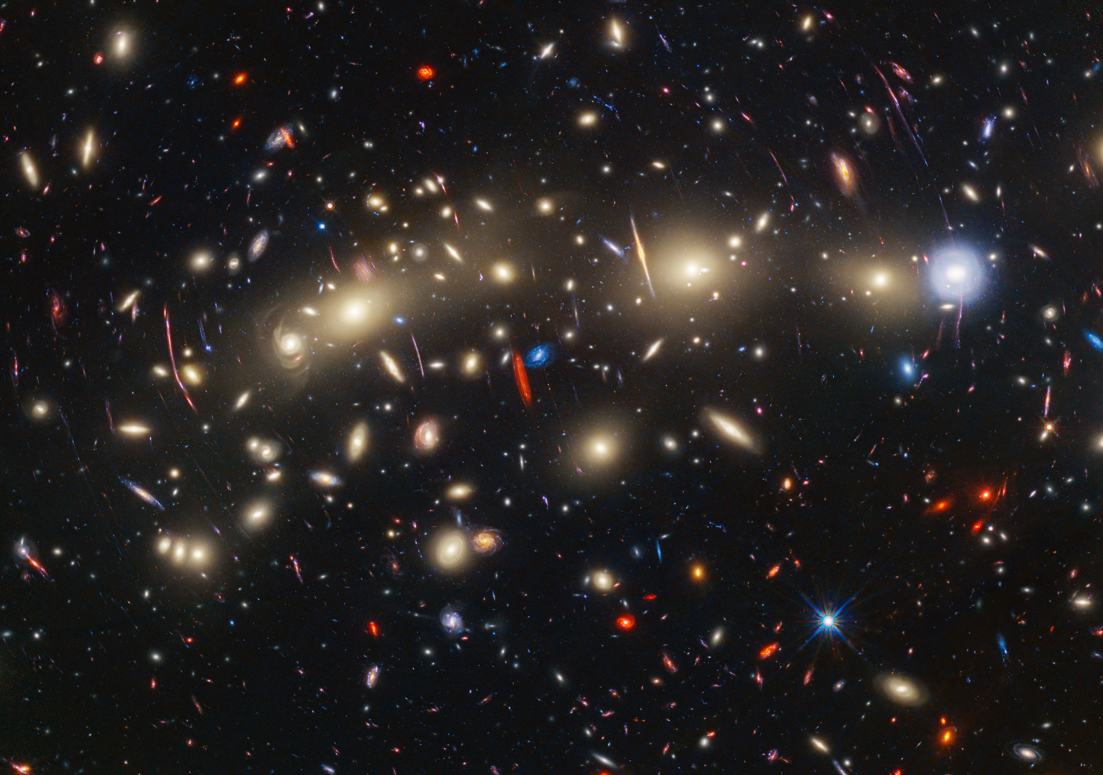 This panchromatic view of galaxy cluster MACS0416 was created by combining infrared observations from NASA’s James Webb Space Telescope with visible-light data from NASA’s Hubble Space Telescope