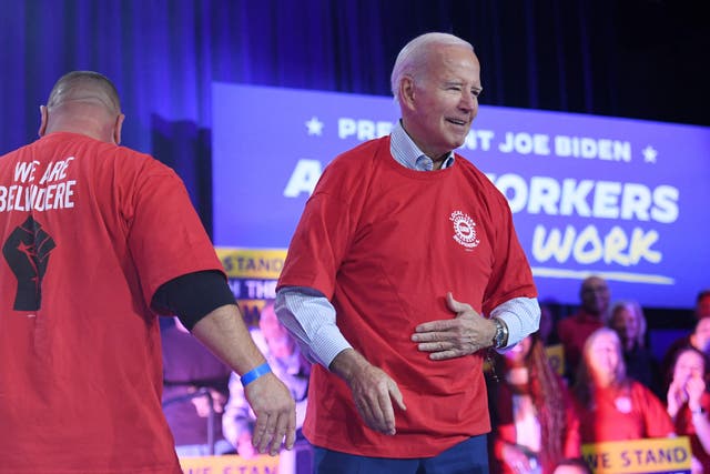 <p>US President Joe Biden puts on a local United Auto Workers shirt as he arrives to speak about the economy and the deal between the United Auto Workers (UAW) Union and the big-three automakers, in Belvidere, Illinois, on November 9, 2023</p>