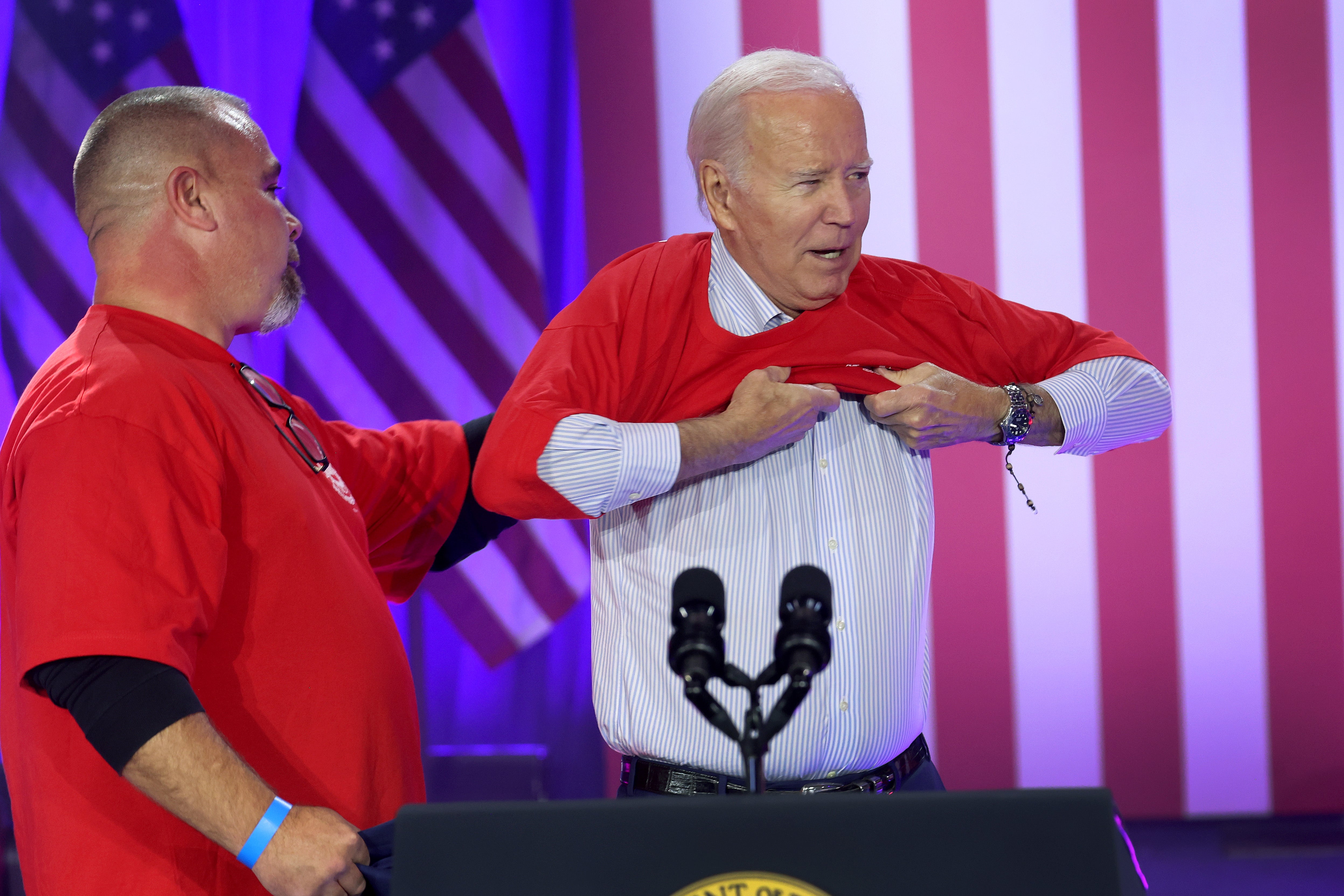 Biden puts on a United Auto Workers shirt before speaking to autoworkers in Belvidere, Illinois
