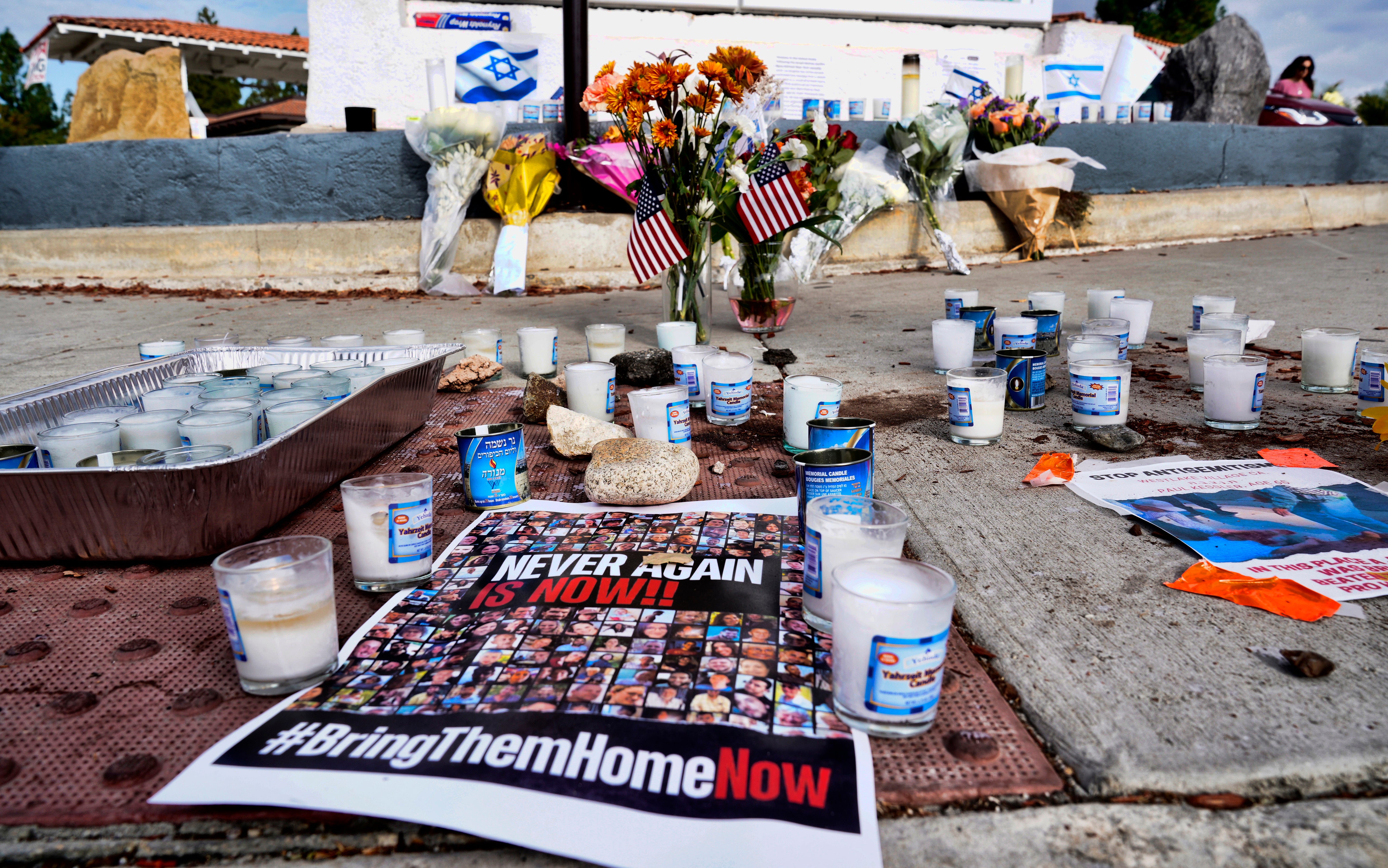 Flowers and candles are left at a makeshift shrine placed at the scene of a Sunday confrontation that lead to death of a demonstrator, Tuesday, Nov. 7, 2023, in Thousand Oaks, Calif.