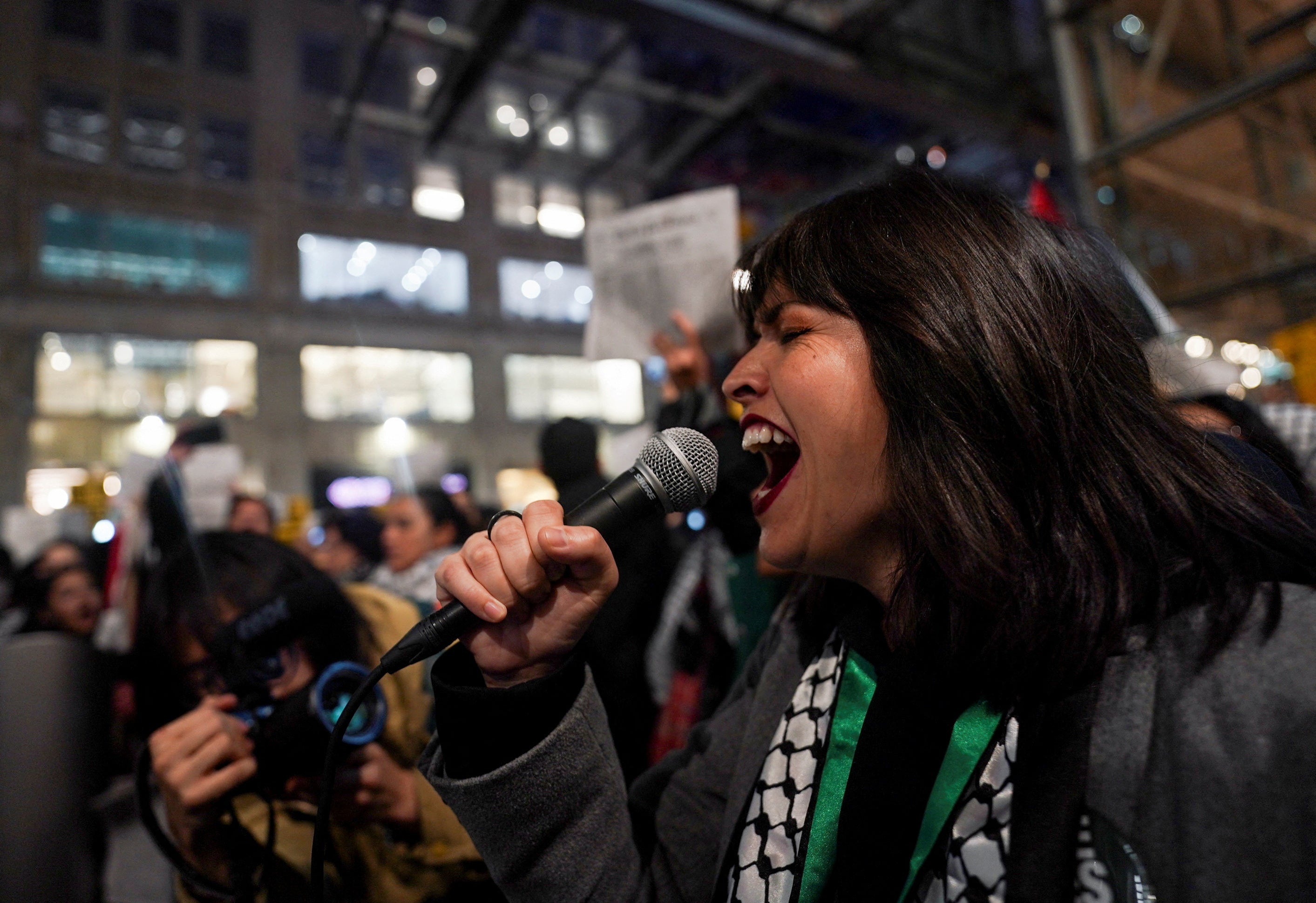A woman uses a microphone at a rally in support of Palestinians in Gaza outside the New York Times building
