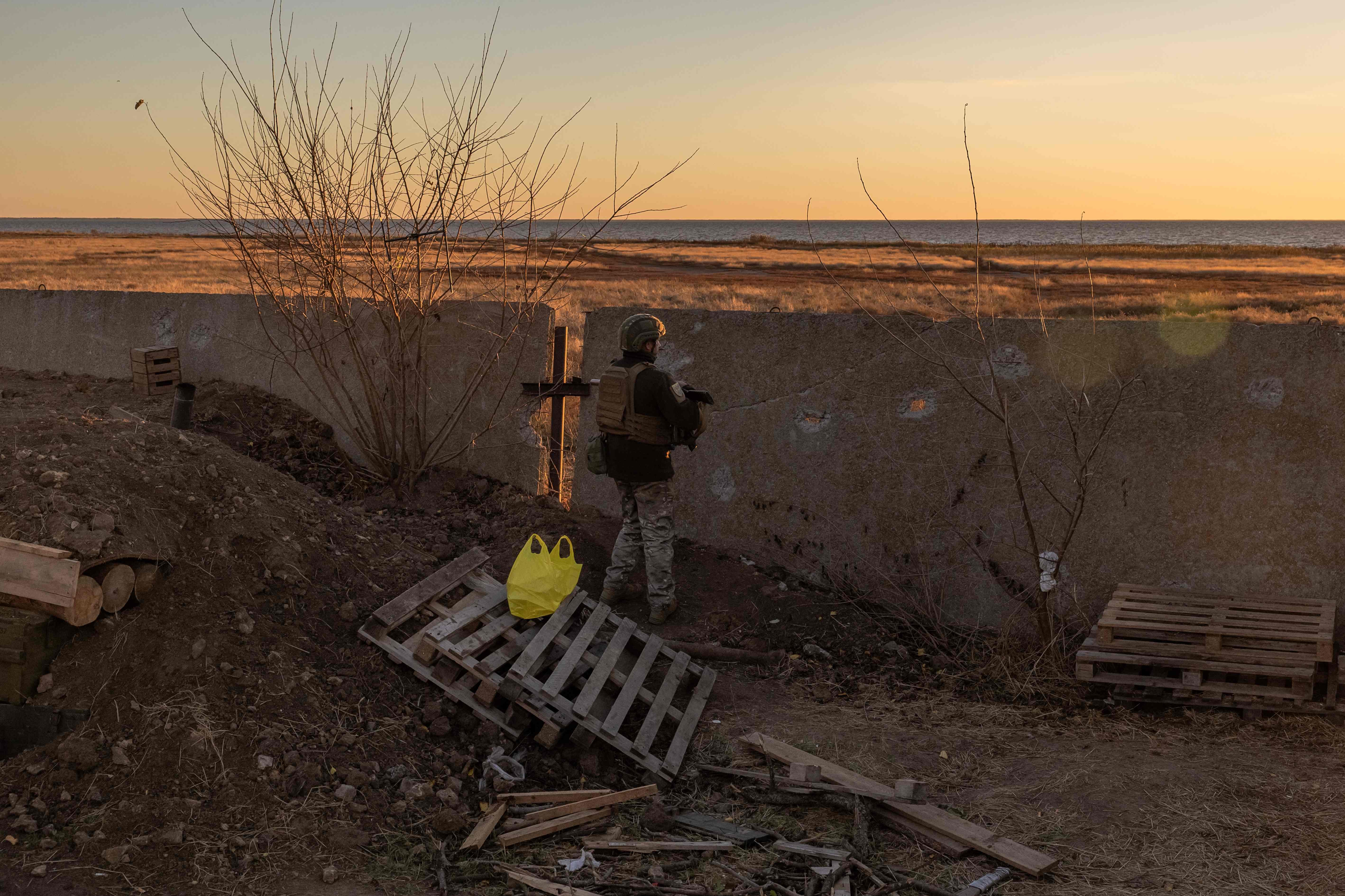 A Ukrainian serviceman of the 123rd Territorial Defense Brigade stands guard on a position next to the Dnipro River