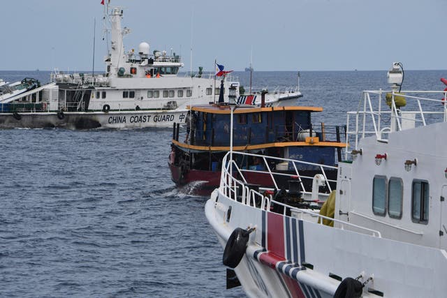 <p>File Chinese coast guard ships and a corral a Philippine civilian boat chartered by the Philippine navy to deliver supplies to Philippine navy ship BRP Sierra Madre in the disputed South China Sea, on 22 August 2023</p>