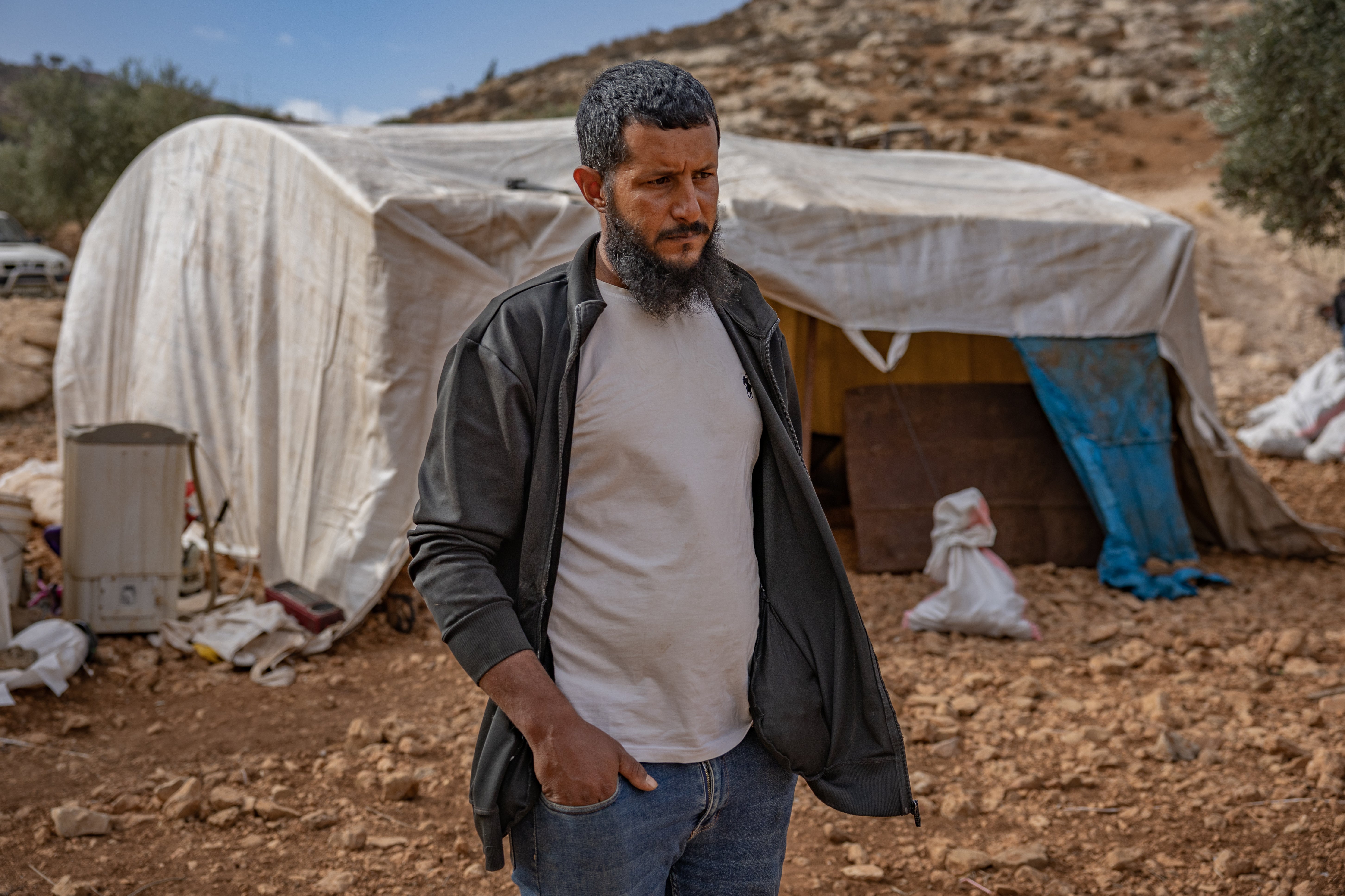 Ali Arrara, 35, by a tent in an olive grove where his family is now camping