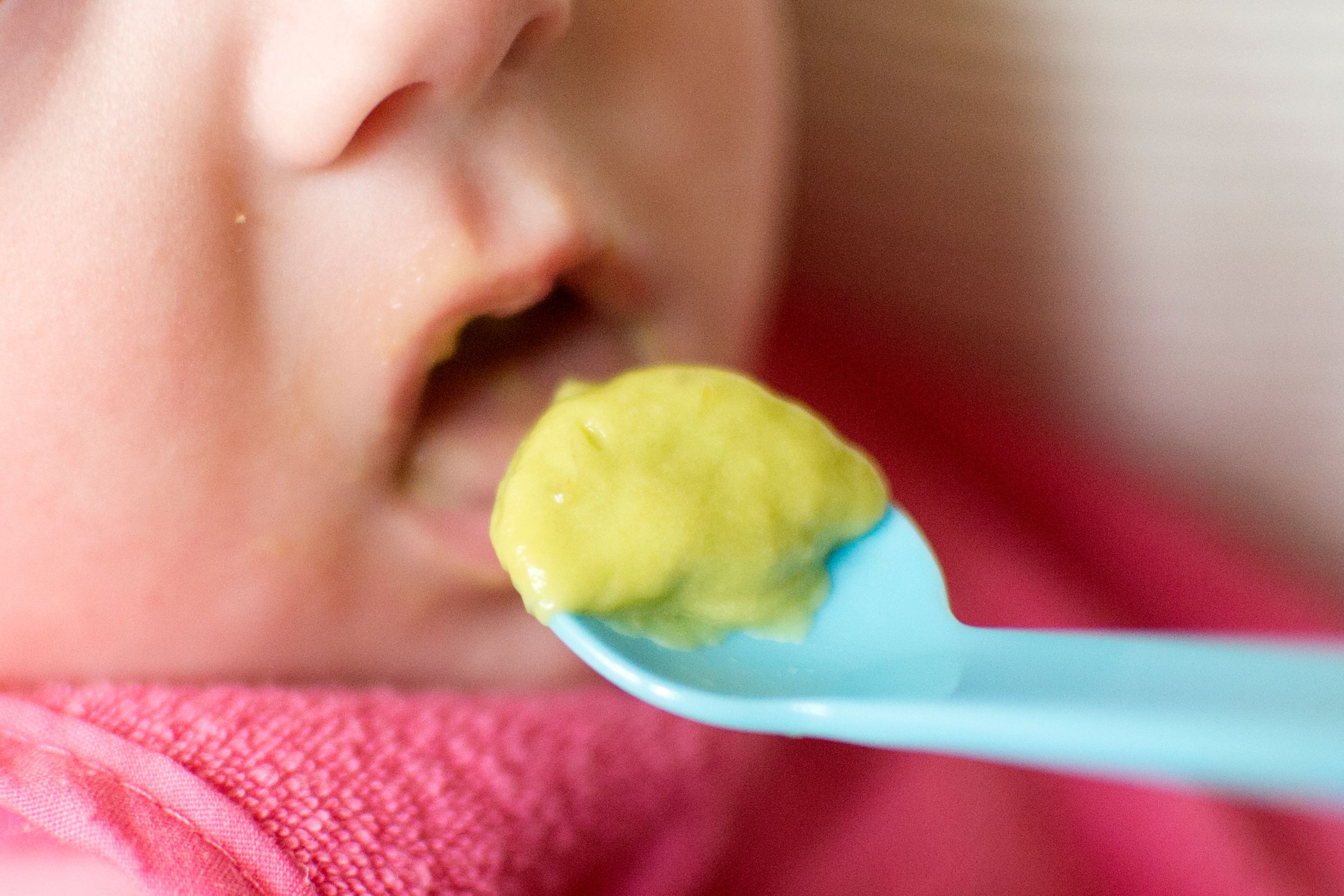 A six month old baby eats puree during weaning.