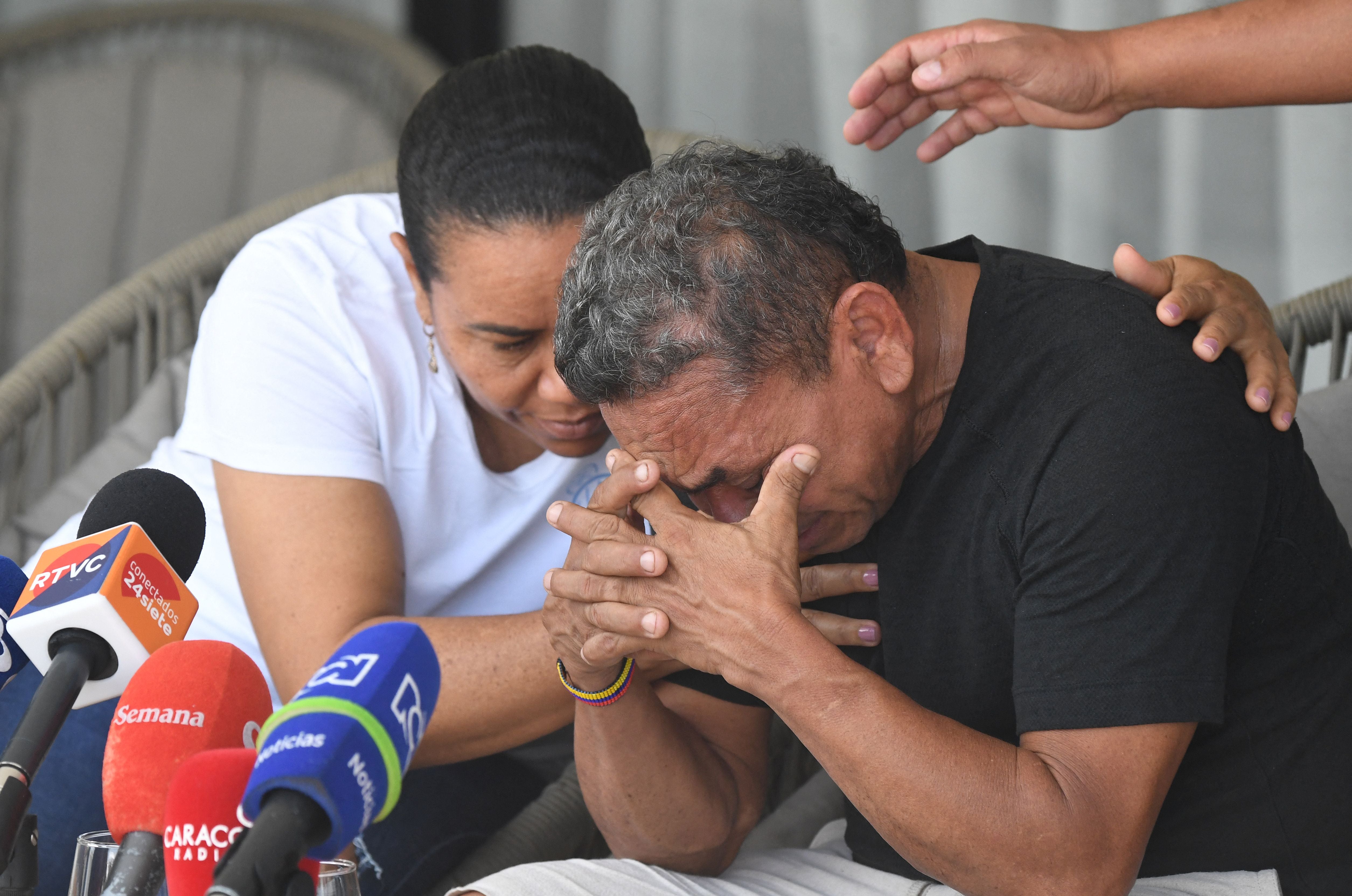 Luis Manuel Diaz, father of Liverpool's forward Luis Diaz, is consoled by his wife Cilenis Marulanda during a press conference at his house in Barrancas