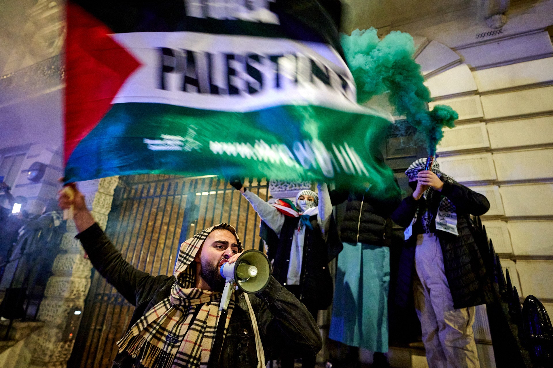 Pro-Palestine protesters set off flares and chant slogans on Millbank during Saturday’s march