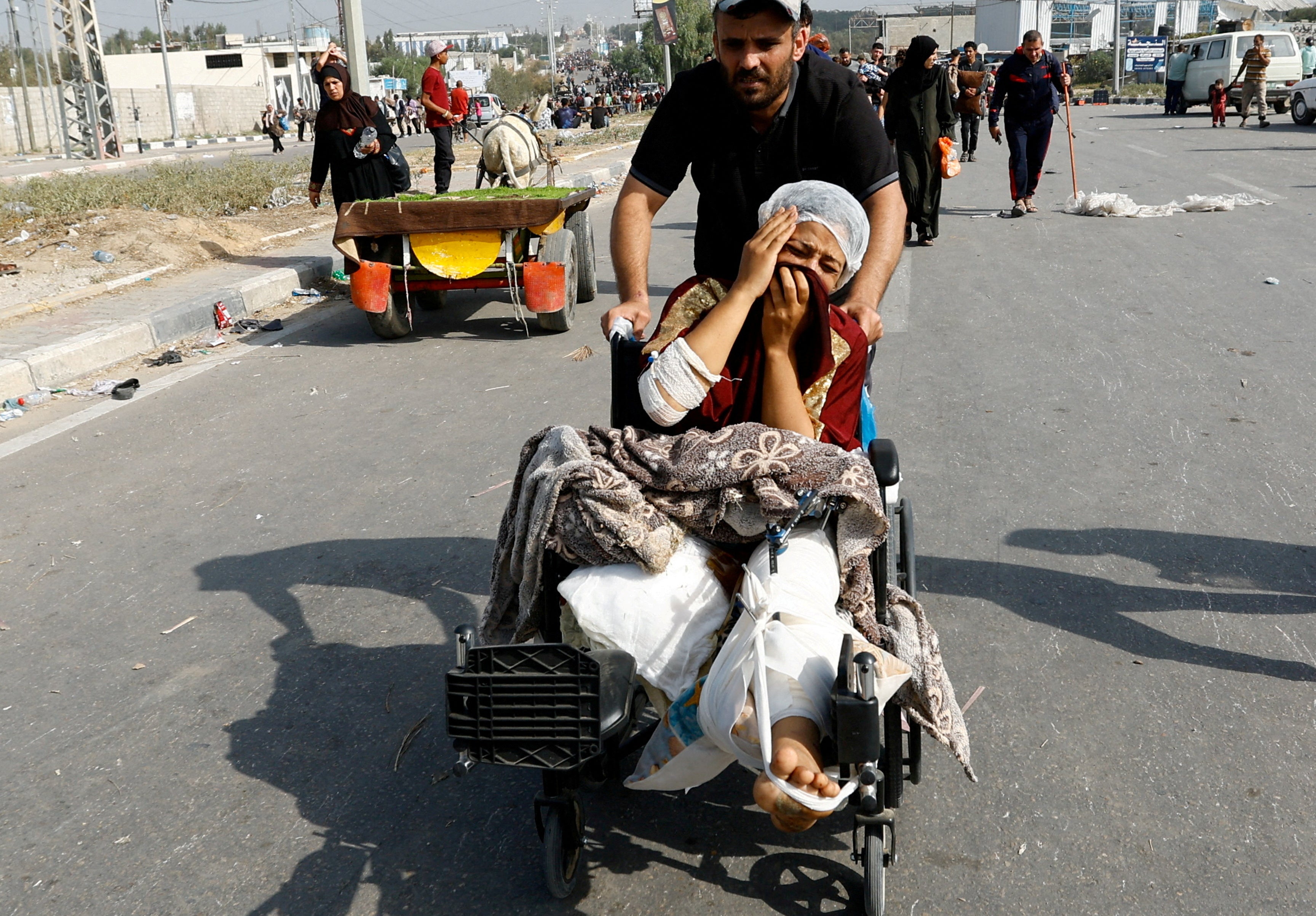 A Palestinian woman, who was being treated at al-Shifa hospital, moves south to avoid the Israeli airstrikes