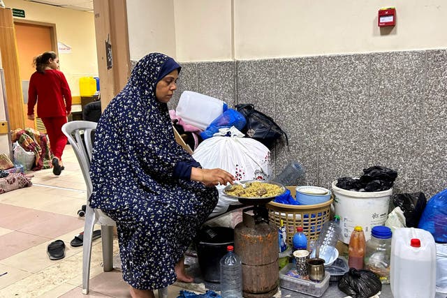 <p>An internally displaced woman cooks while camping at Al-Shifa hospital in Gaza City on 10 November, 2023</p>