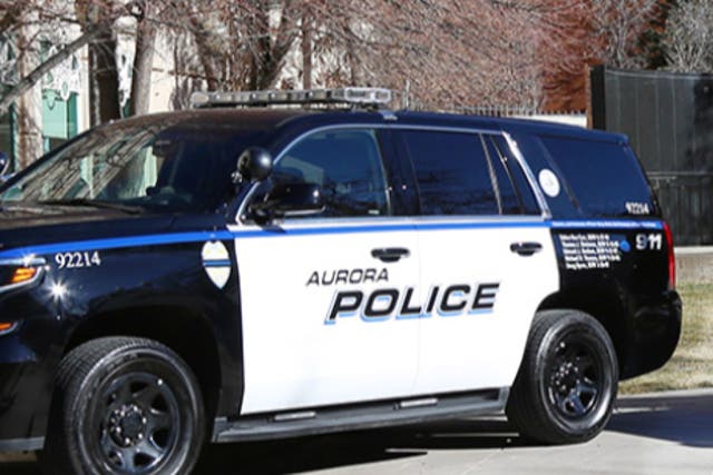 <p>An Aurora, Colorado, police cruiser is parked in front of a building</p>