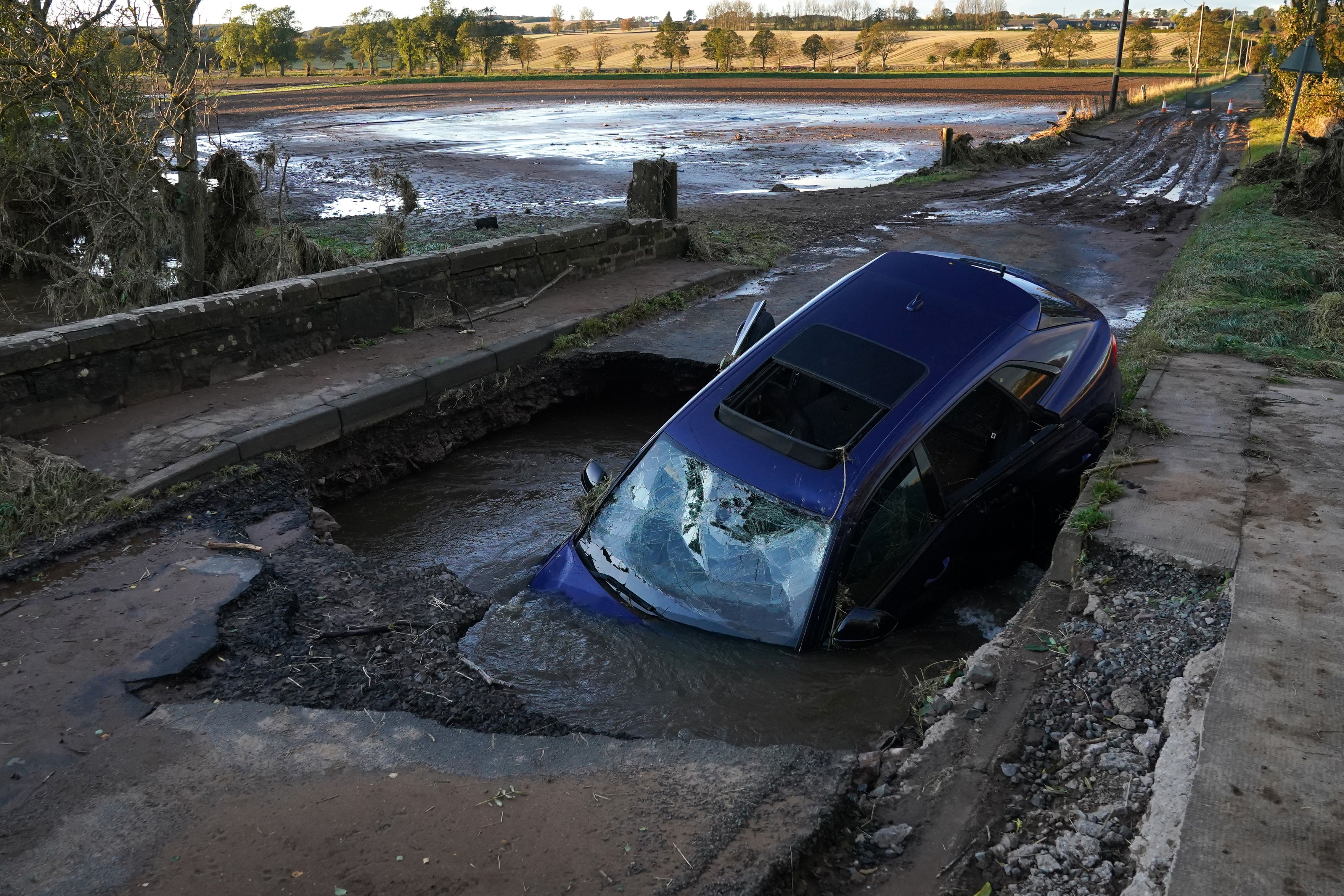 A car is seen on a bridge washed away near Dundee following torrential rain in October (Andrew Milligan/PA)