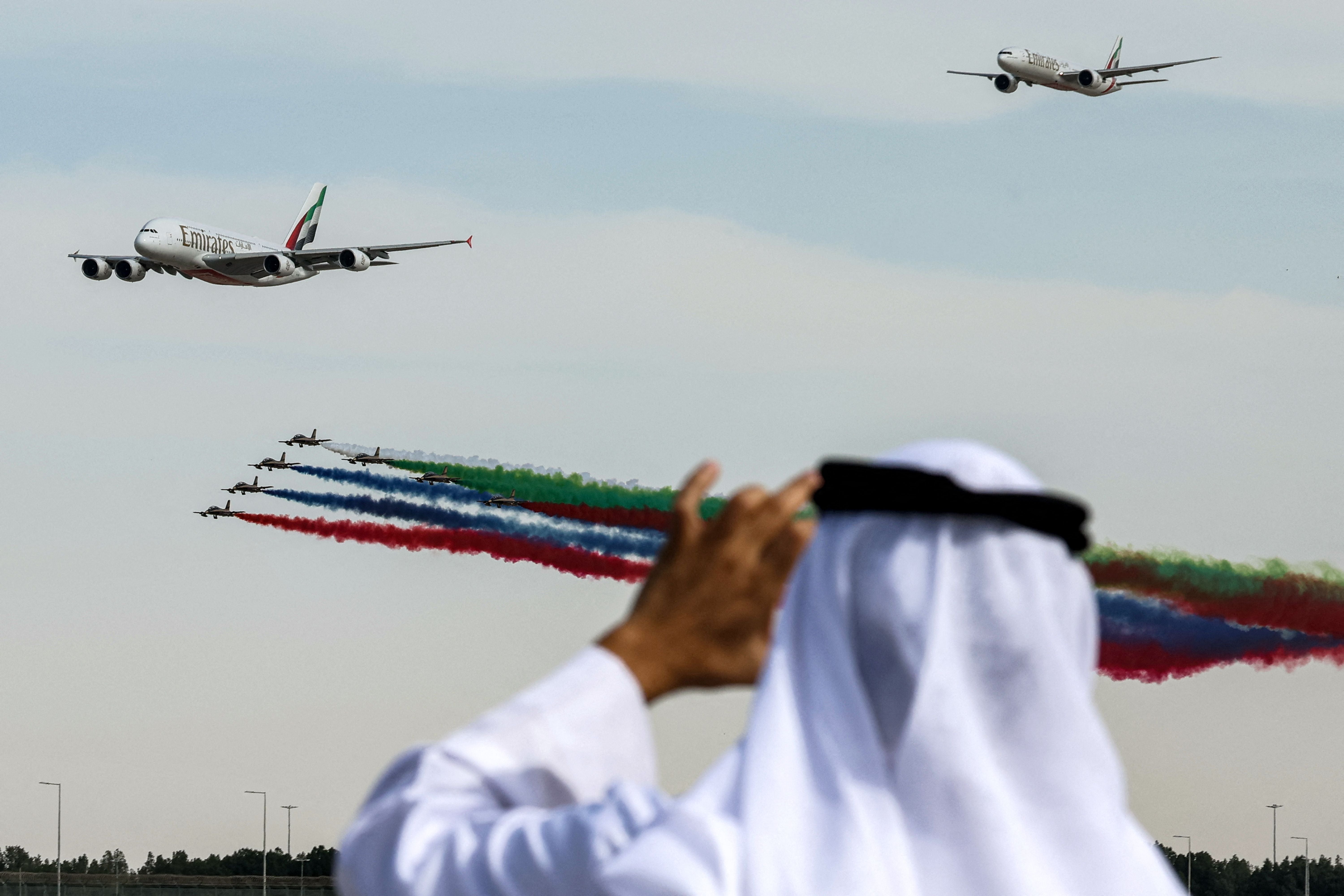 Aermacchi MB-339 trainer aircraft from the Fursan al-Emarat (UAE Knights) aerobatics team release smoke behind an Emirates A380 at the Dubai Airshow on Monday