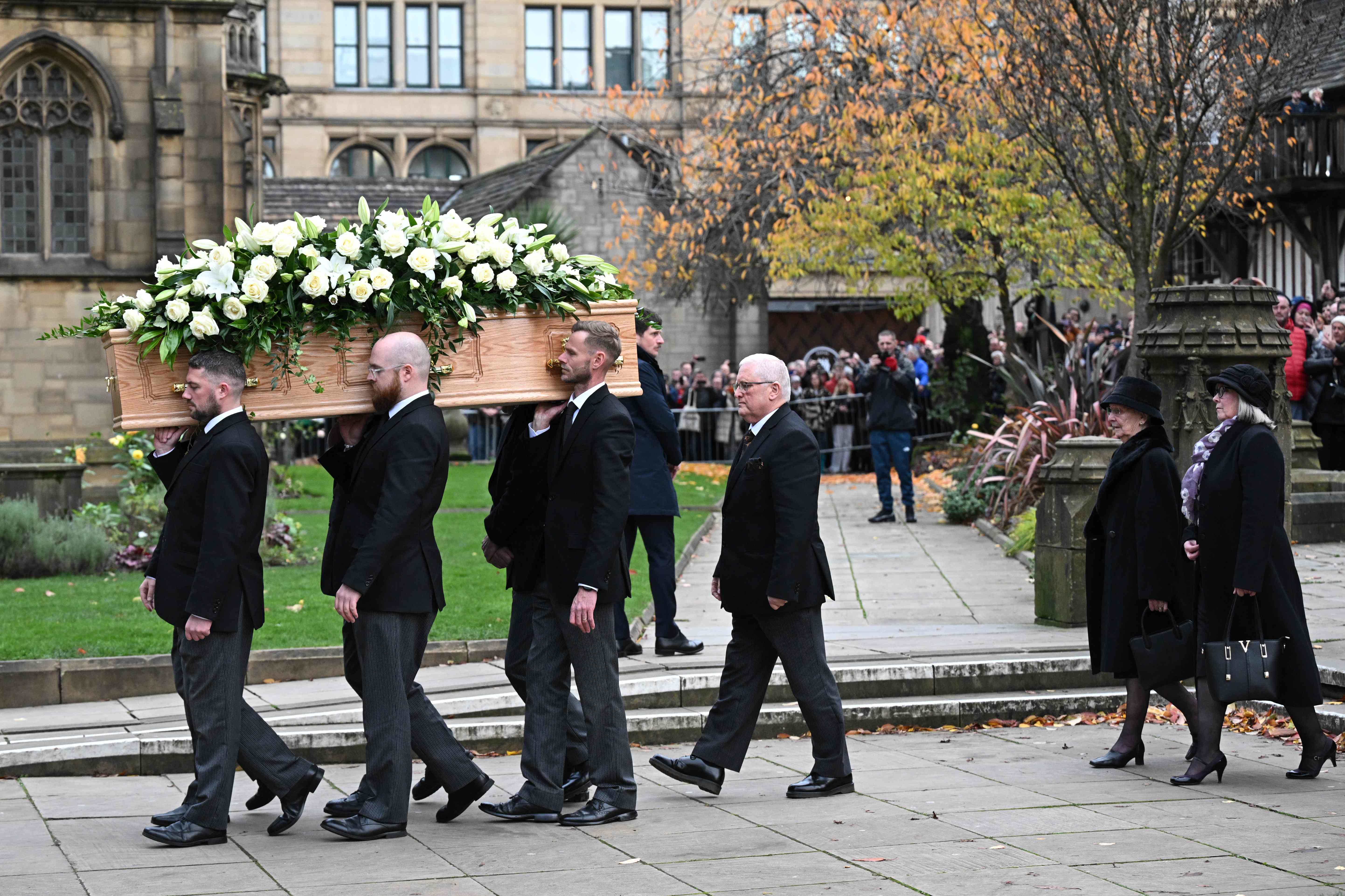 Lady Norma (second right), widow of Sir Bobby, walks behind the pallbearers