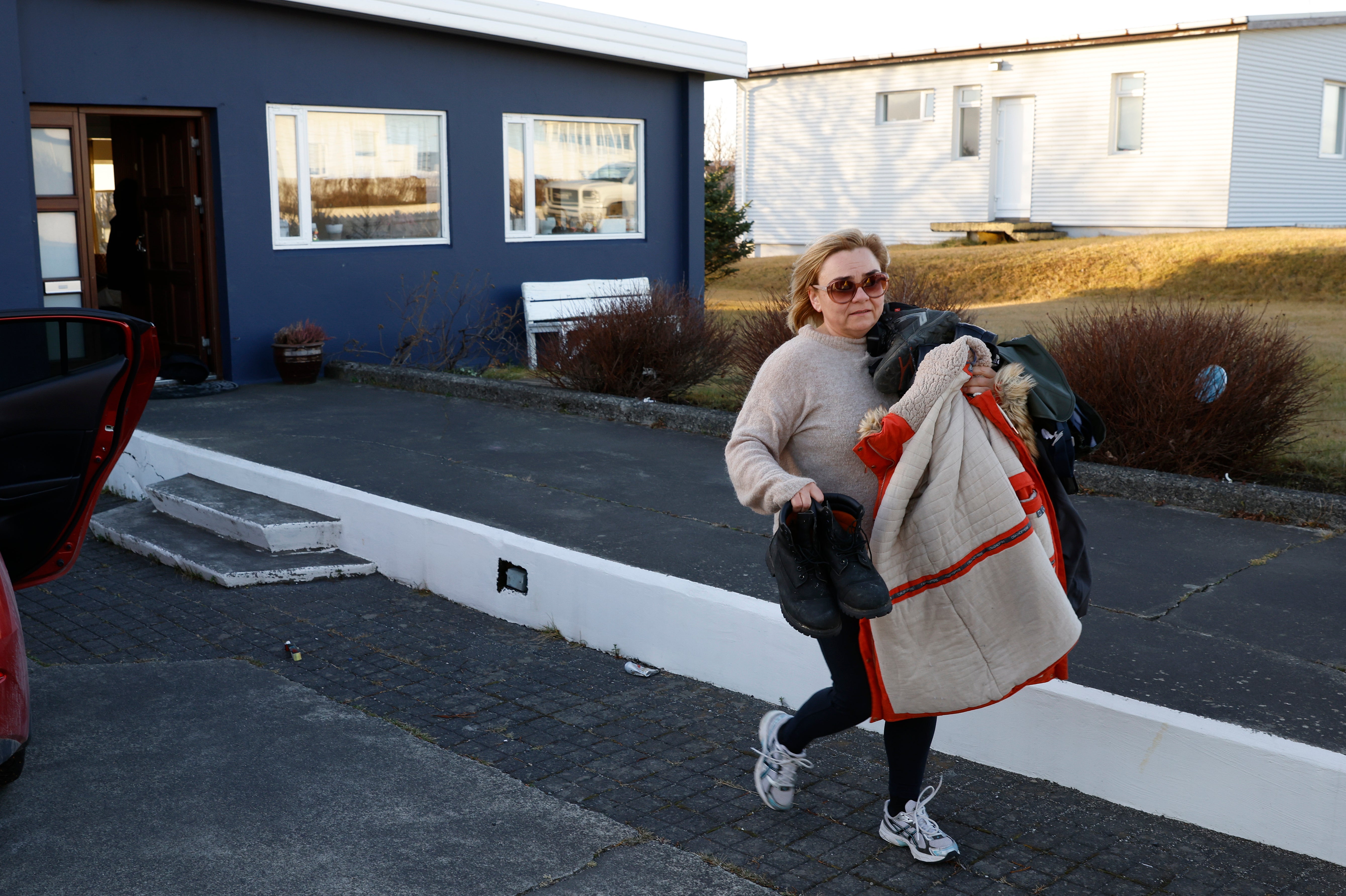 <p>A resident from the town of Grindavik, Iceland, takes some of their belongings from their house</p>