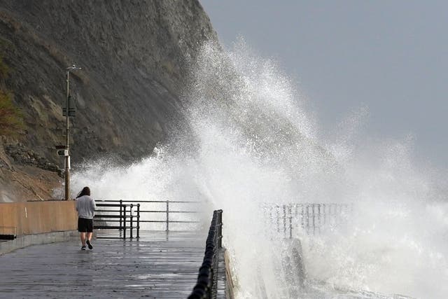 Waves crash over the promenade in Folkestone, Kent (PA)