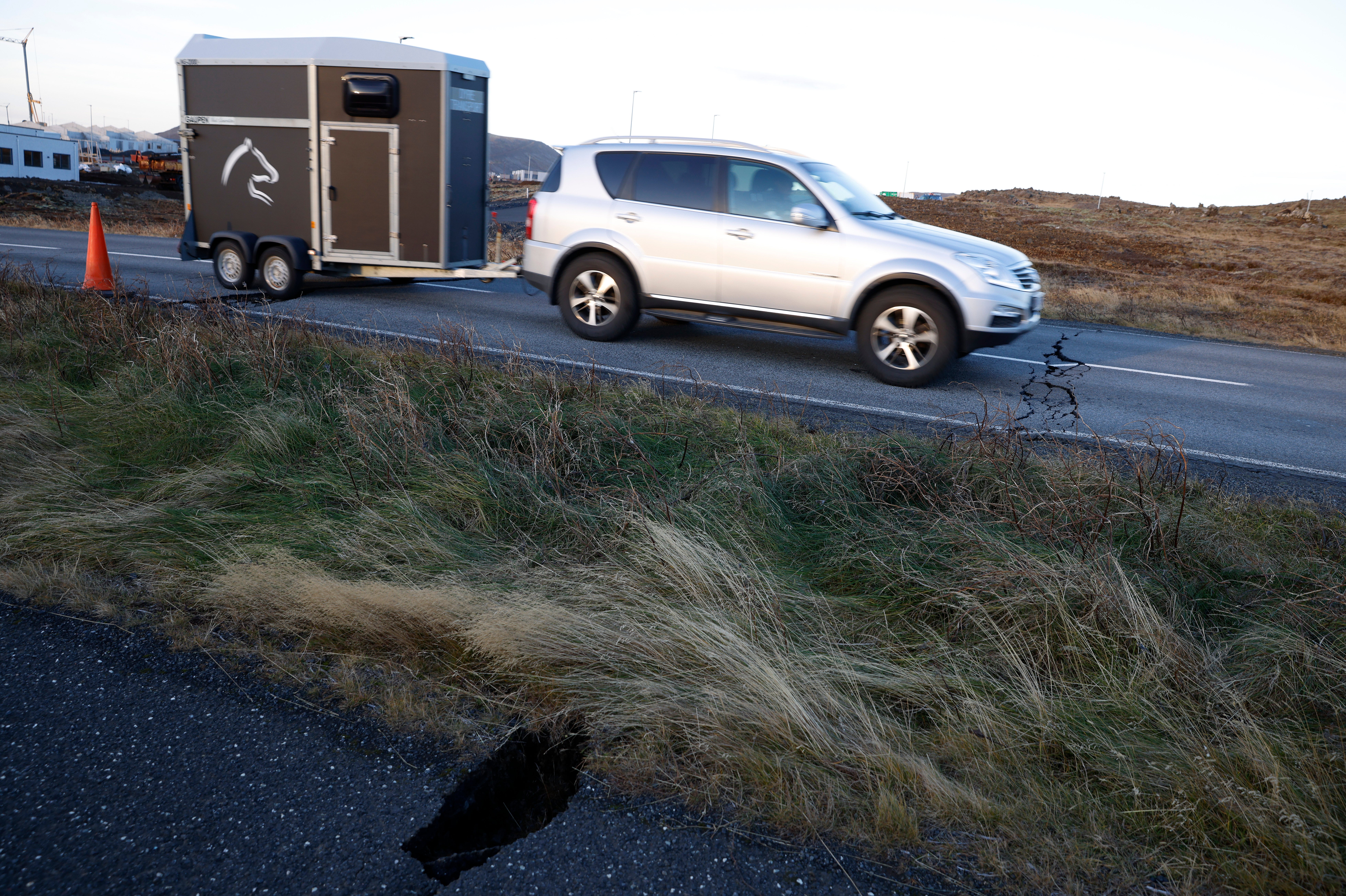 <p>A car drives toward a crack in a road in the town of Grindavik, Iceland on Monday 13 November 2023 following seismic activity</p>