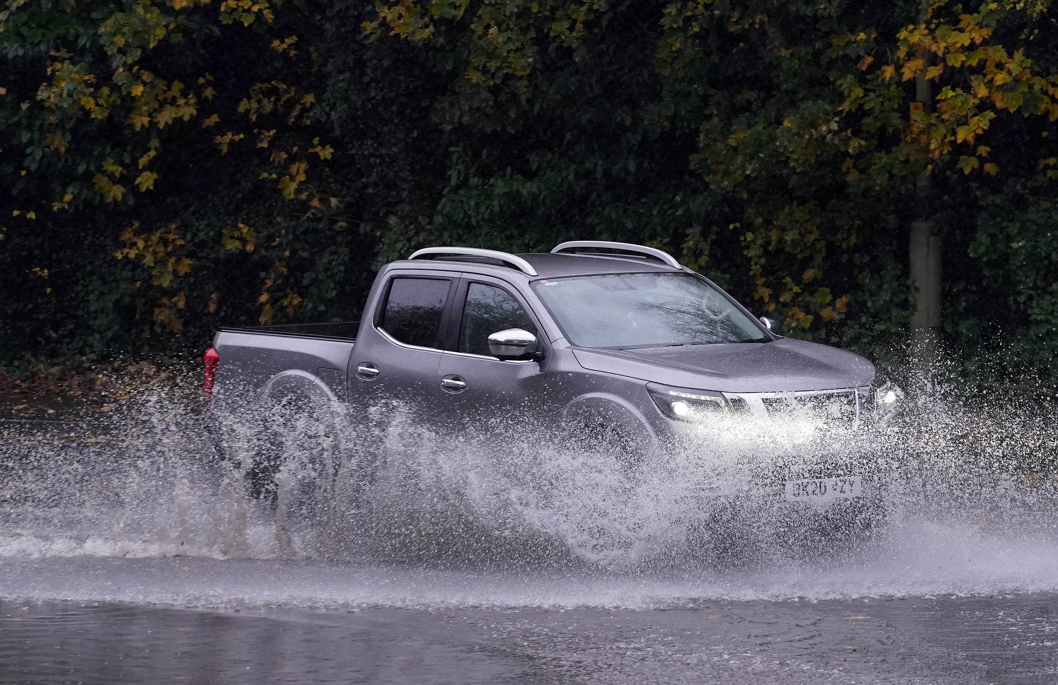 Cars pass through a flooded road in Ashford, Kent on Tuesday