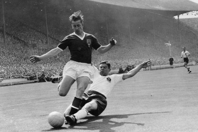 <p>Manchester United’s Bobby Charlton, being slide-tackled by Bolton Wanderers’ Tommy Banks during the 1958 FA Cup final (Keystone/Getty Images)</p>