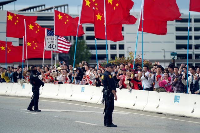 <p>With American and Chinese flags flying, people watch as the motorcade carrying President Joe Biden drives past Tuesday, Nov. 14, 2023, in San Francisco. </p>