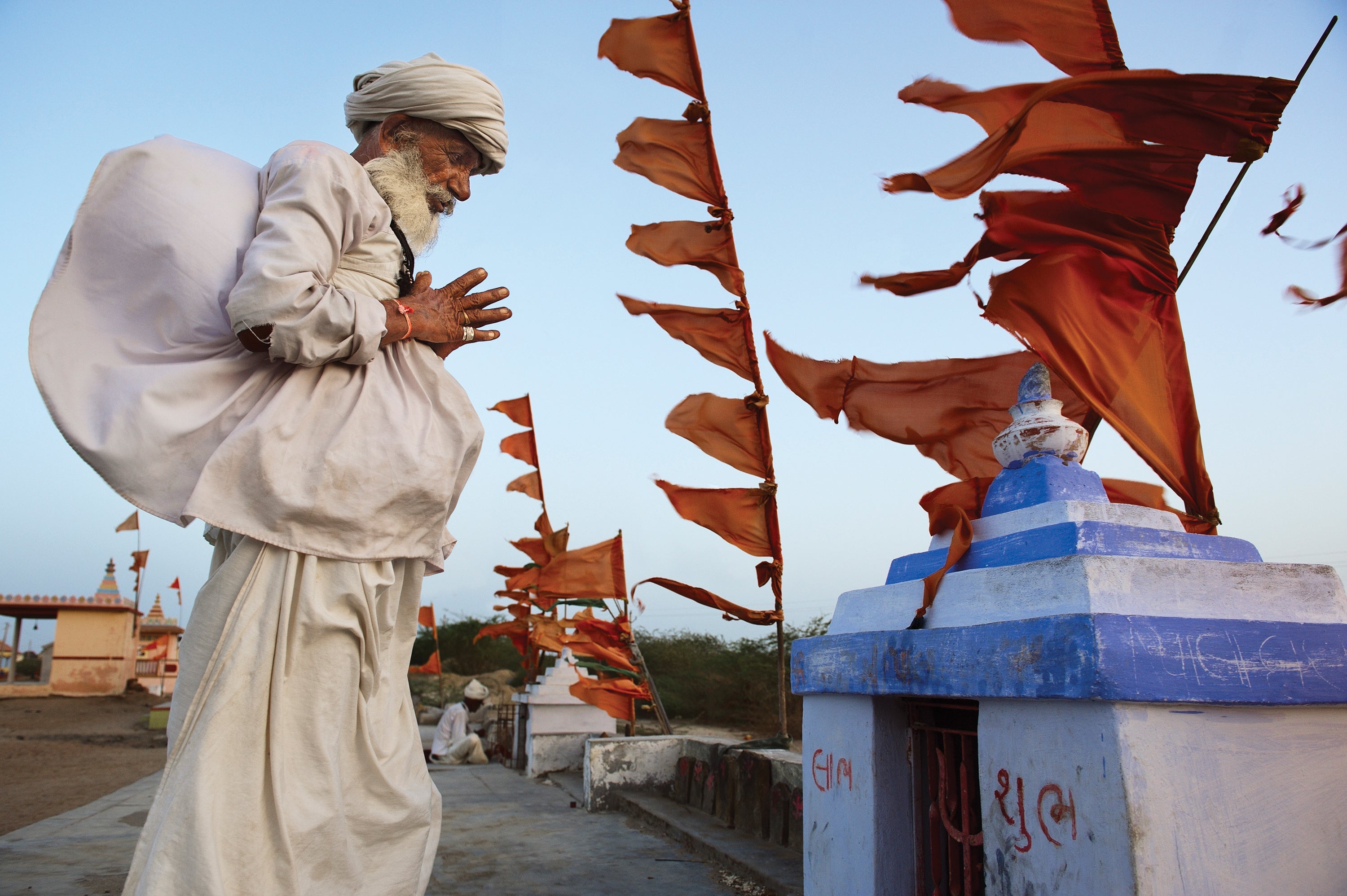 In simple terms, the contrast between the man on the left, serenely praying in Gujarat, India, and the fluttering flags to the right, makes for a visually arresting image. On closer scrutiny one can see that the colour of the flags is mirrored in the colours of the man's painted fingernails and his bracelet