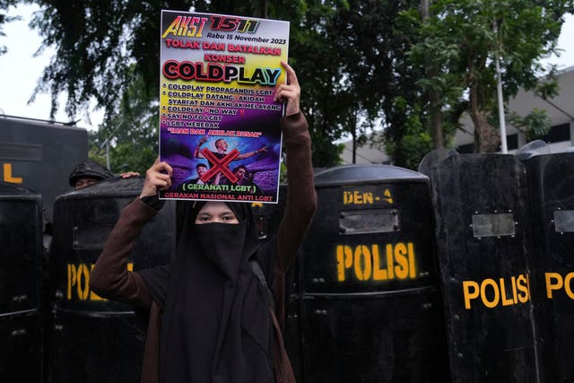 <p>A woman holds a poster during a rally against British band Coldplay ahead of its concert in Jakarta, Indonesia, Wednesday, 15 November 2023 </p>