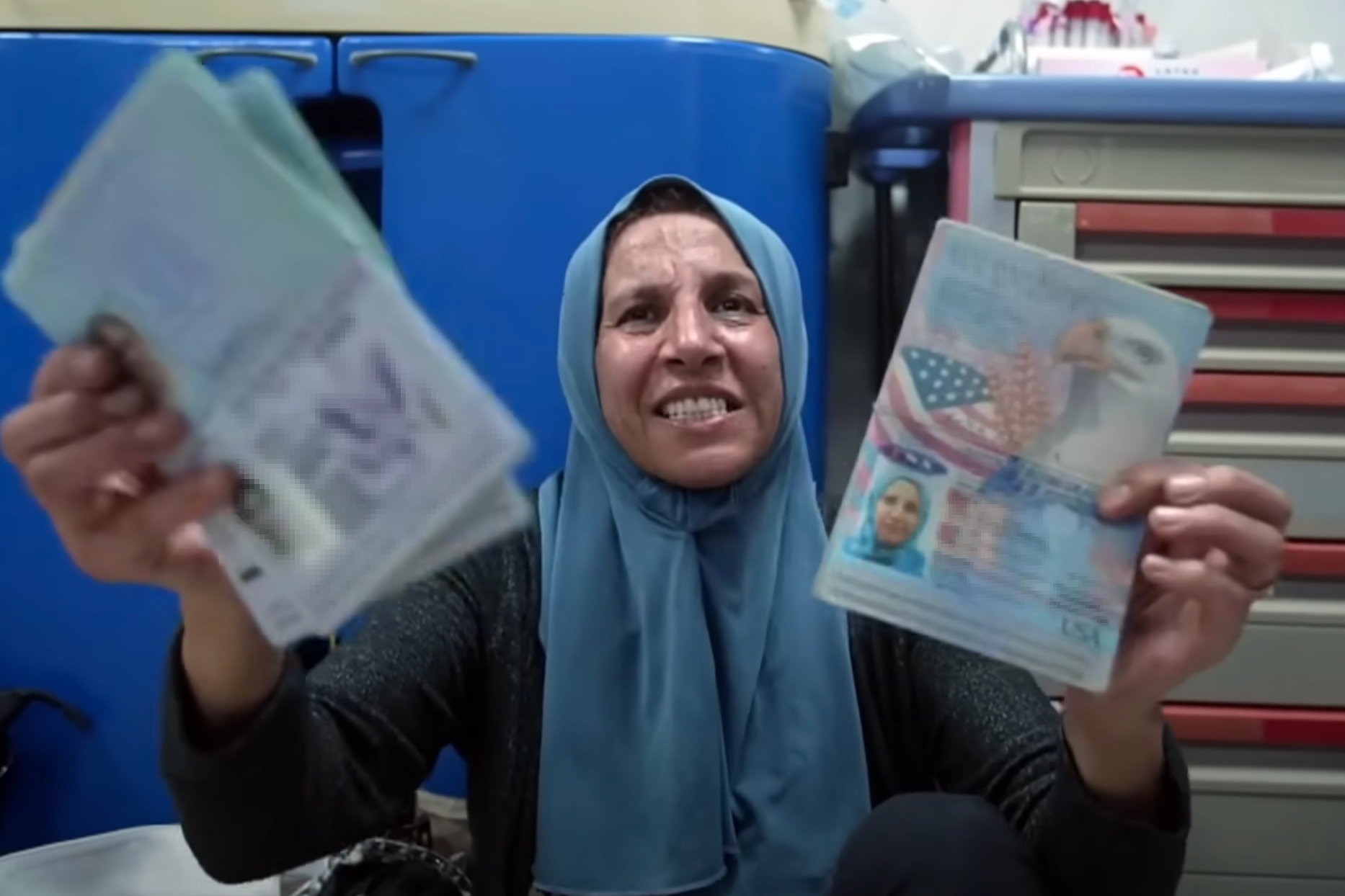 Noha Abuolba holds up her American passport in a Gaza hospital after a car carrying her and her daughters is hit by an apparent airstrike