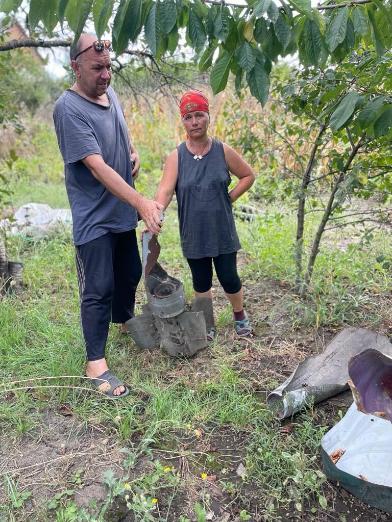 Serhei and Iryna Olynik with parts of explosive devices left in the garden