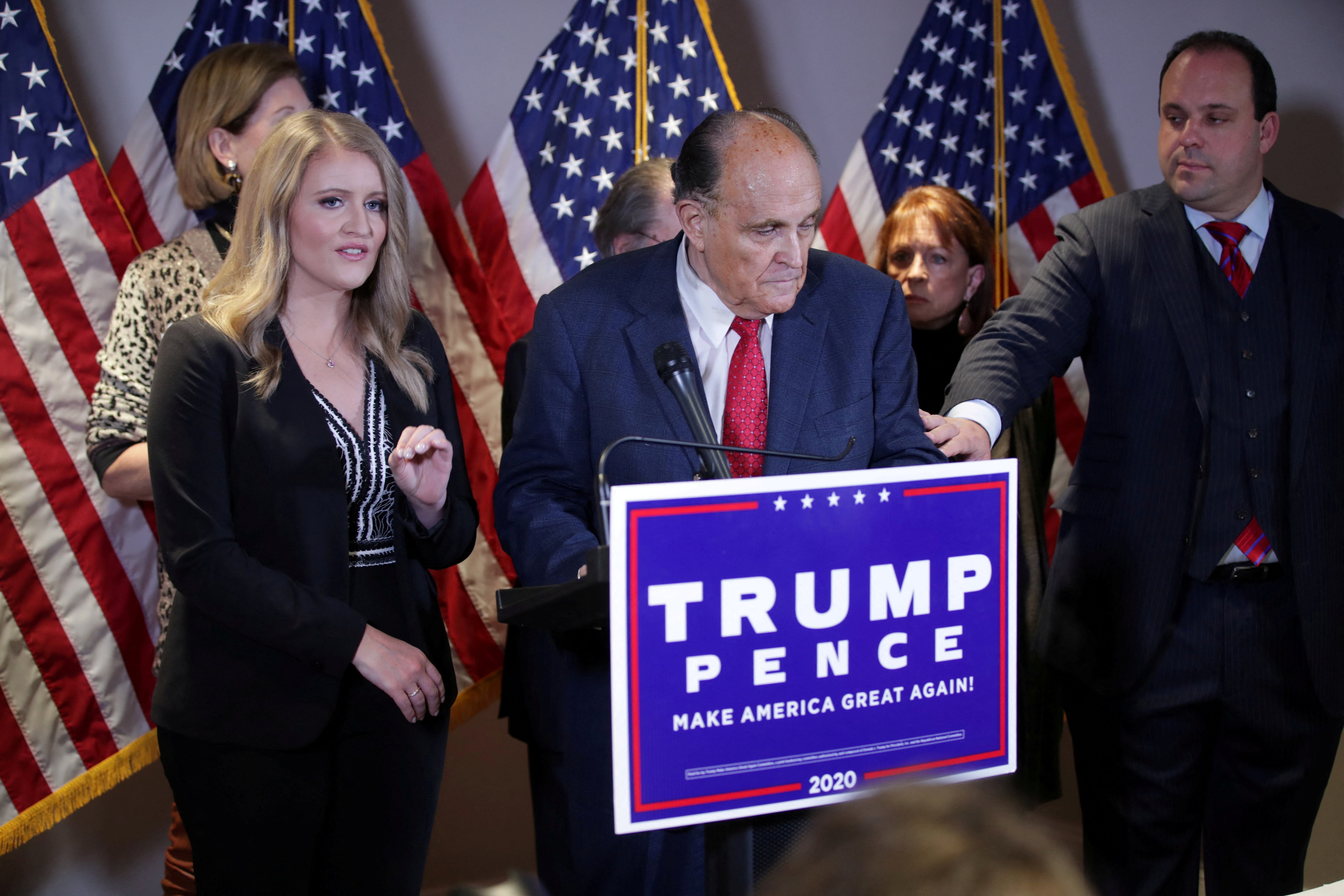 Rudy Giuliani speaks at a press conference next to Jenna Ellis, left, amplifying bogus fraud claims in the wake of the 2020 election