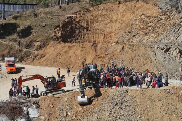 <p>People watch rescue and relief operations at the site of an under-construction road tunnel that collapsed in mountainous Uttarakhand state, India, Wednesday, 15 November 2023 </p>