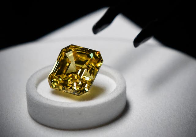 <p>File: An employee of Russia’s diamond miner Alrosa displays a 20.69-carat square emerald cut bright yellow diamond in Moscow </p>