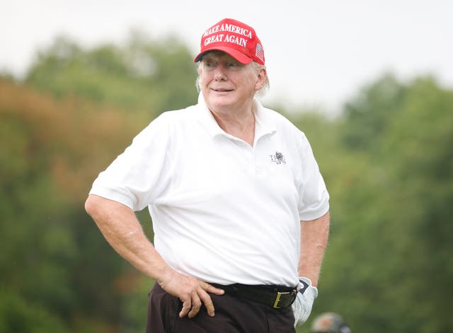 <p>Donald Trump striking a pose on the golf course </p>