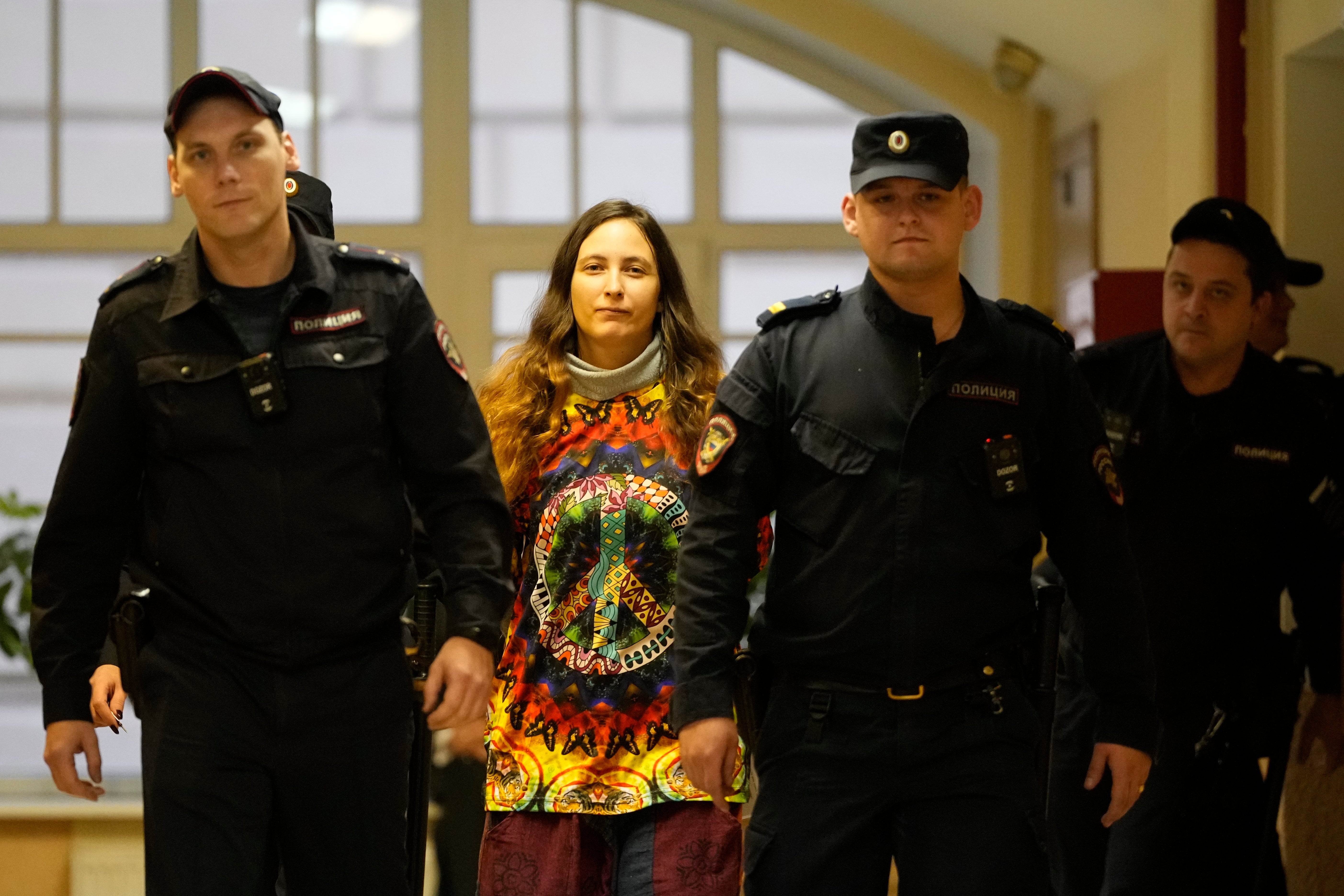 Sasha Skochilenko, a 33 year-old artist and musician, second left, is escorted by officers to the court room for a hearing in the Vasileostrovsky district court in St. Petersburg