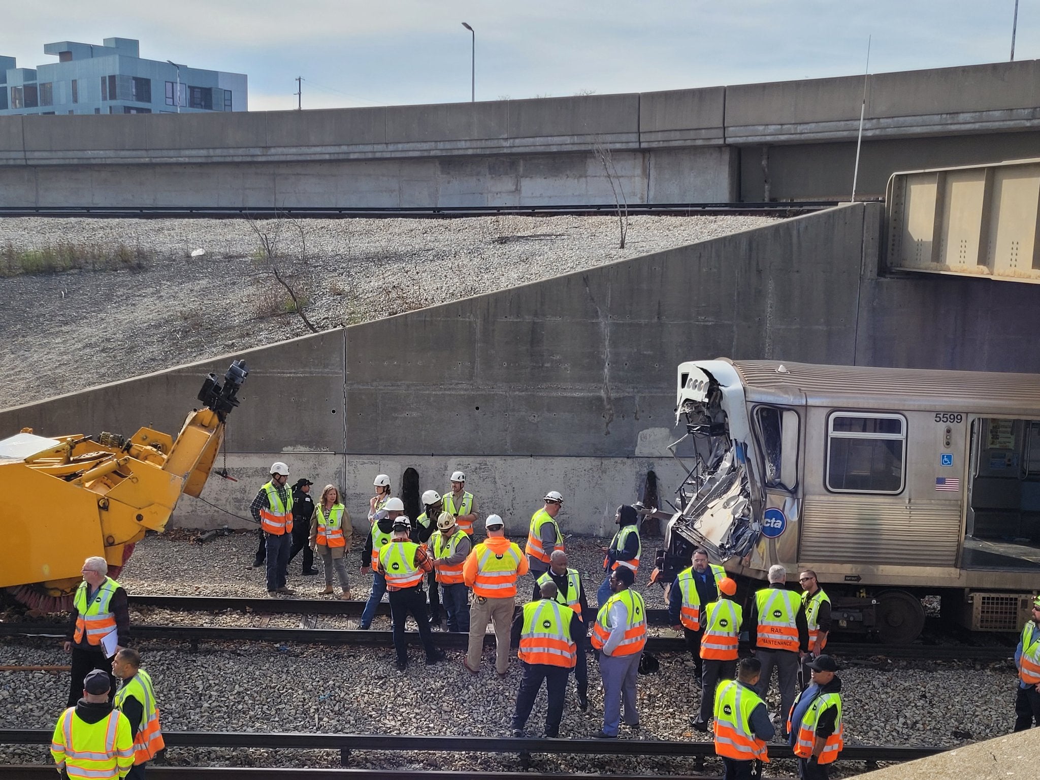 Workers examin the damage to a CTA train in Chicago, Illinois after it crashed into snow-removal equipment
