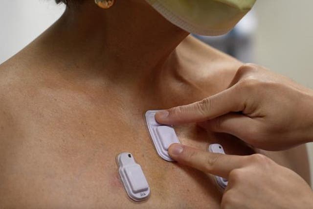 <p>A health care worker places the wearable devices across a patient's chest to capture sounds throughout the lungs that are associated with breathing</p>