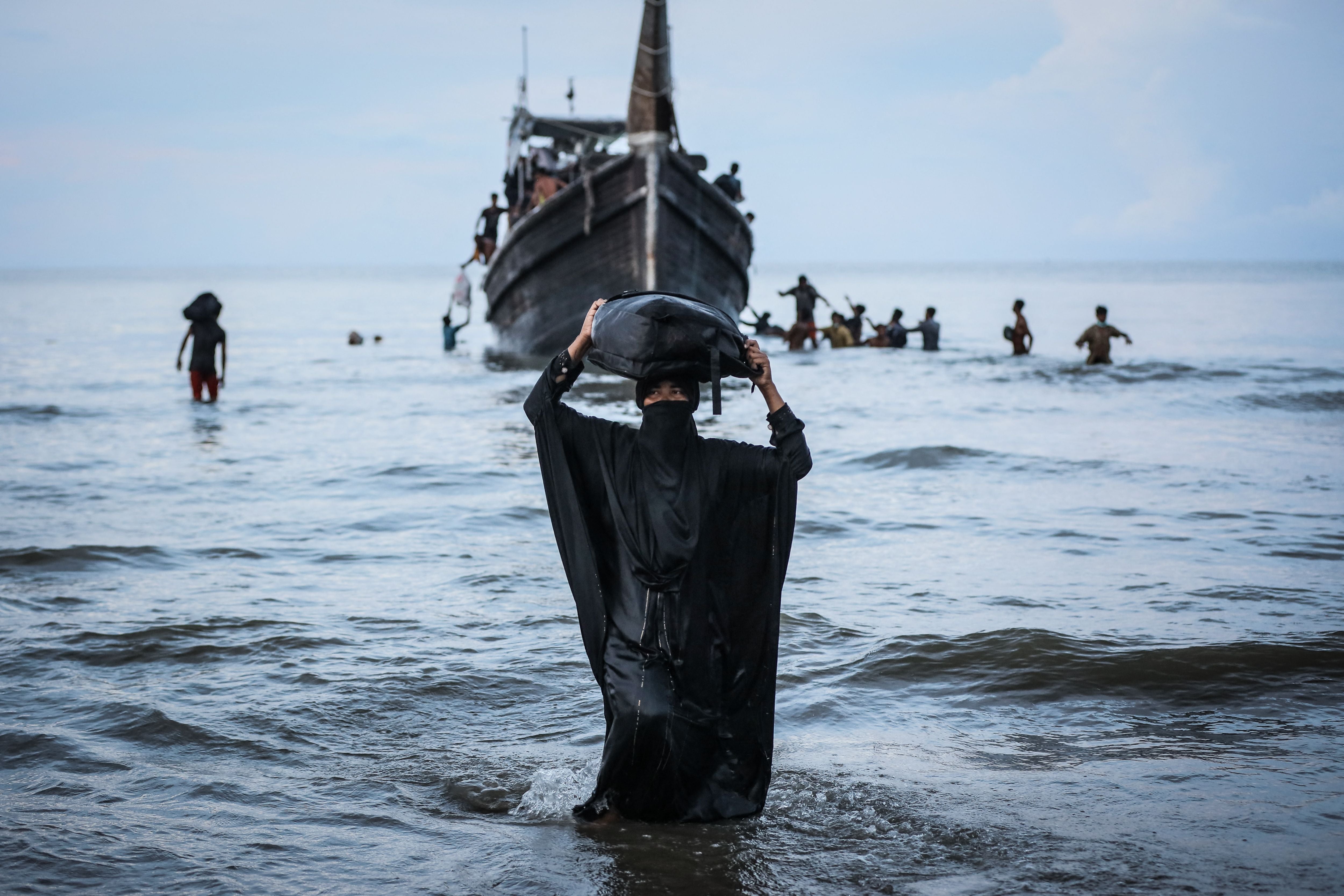A newly arrived Rohingya refugee walks to the beach after the local community decided to temporarily allow them to land for water and food in Ulee Madon, Aceh province, Indonesia